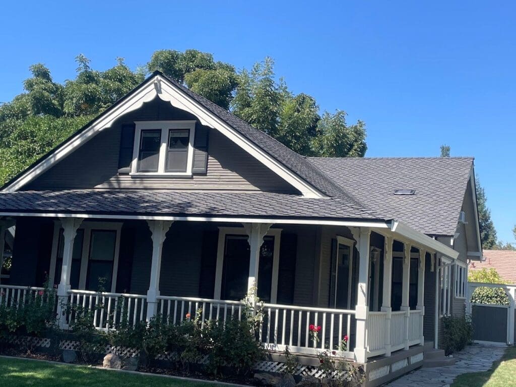Completed roof on a craftsman-style home with a wraparound porch